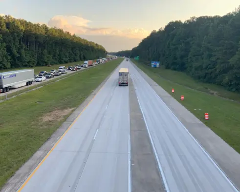 A truck driving down the middle of an interstate.